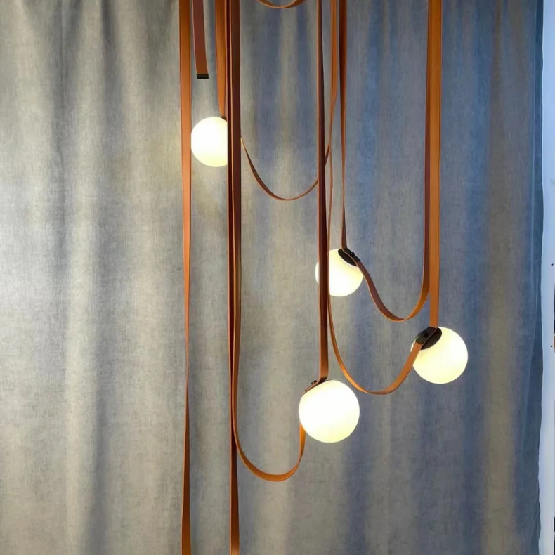 Suspension luxueuse en cuir italien avec plusieurs lampes LED, créant une ambiance élégante dans les grands espaces.