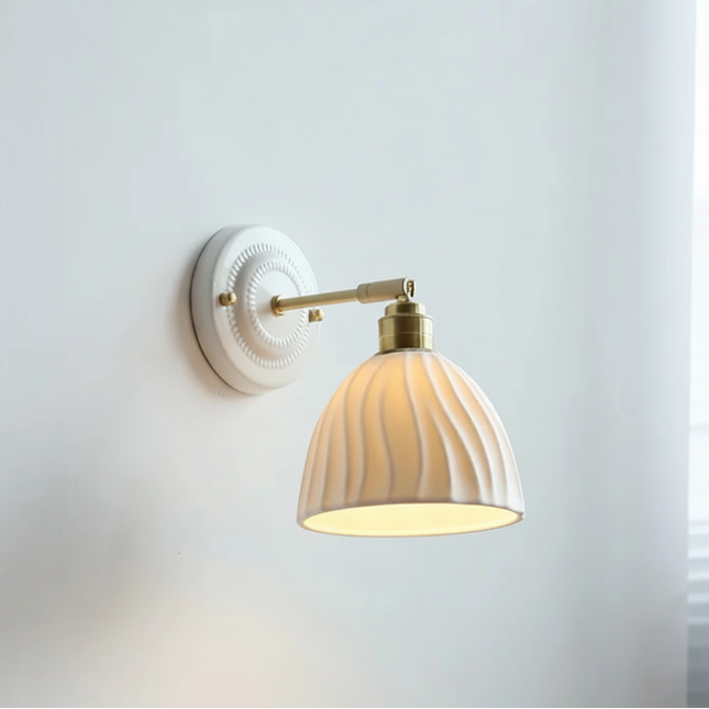 Aplique de pared vintage con pantalla de cerámica ranurada y brazo de latón.