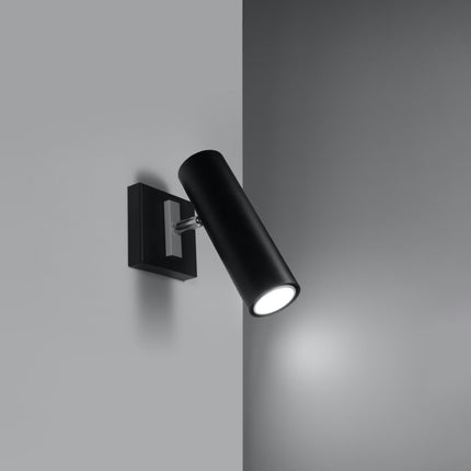 Applique acier orientable noire allumée dans un angle de mur gris
