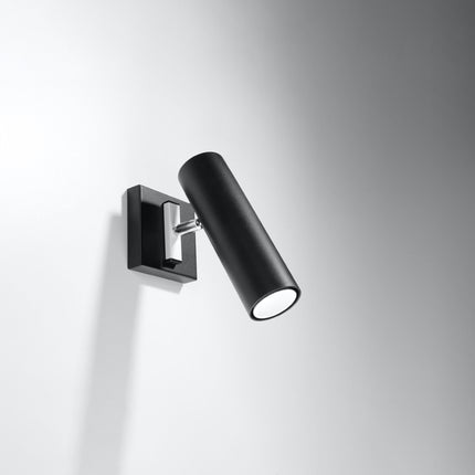 Applique acier orientable noire fixée sur un mur gris, tête cylindrique inclinée