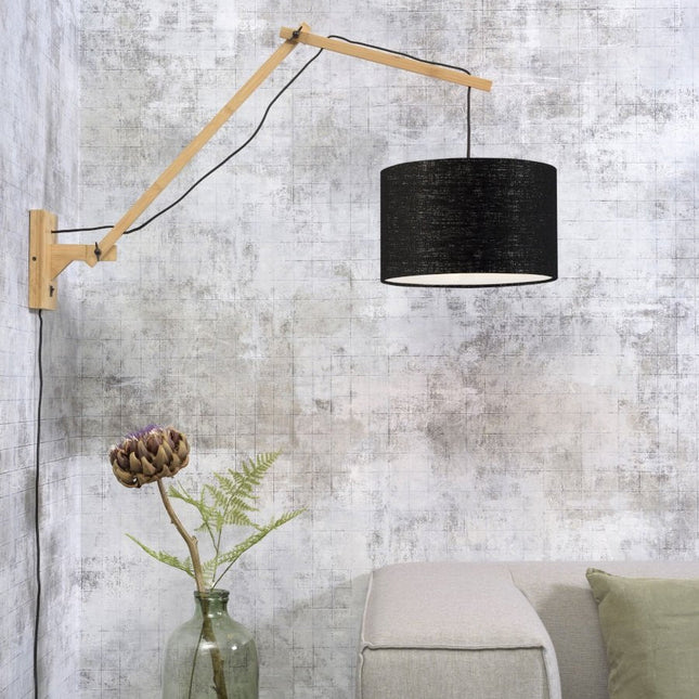 Andes wall light in bamboo and black écolin installed above a beige sofa