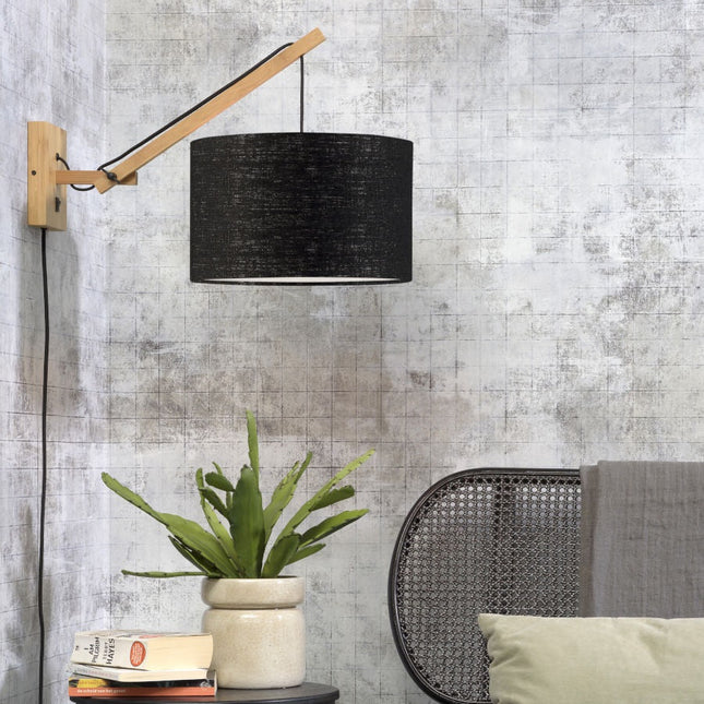 Applique murale Andes bambou et lin noir suspendue au-dessus d'une table d'appoint dans un salon