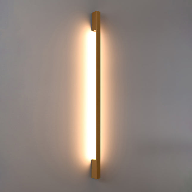 Applique Barre Contemporaine dorée allumée, halo blanc chaud diffusé le long du mur