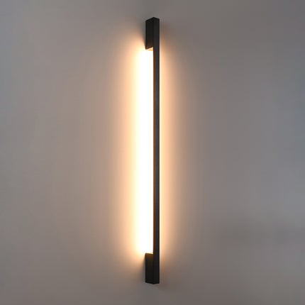 Applique Barre Contemporaine noire allumée, halo blanc chaud diffusé le long du mur