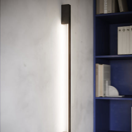 Applique Barre Contemporaine noire allumée sur un mur béton dans un intérieur design