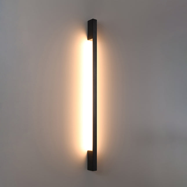 Applique Barre Contemporaine noire allumée, halo blanc chaud diffusé le long du mur