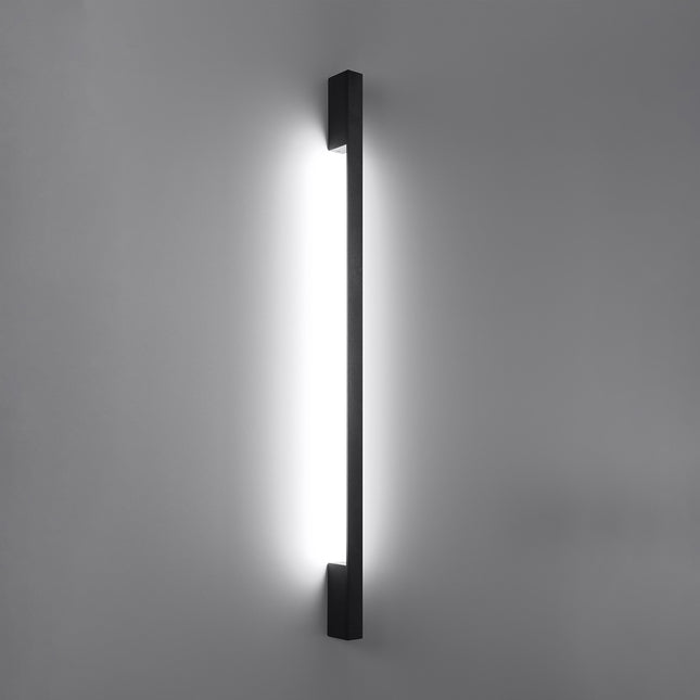 Applique Barre Contemporaine noire allumée, halo blanc neutre diffusé le long du mur