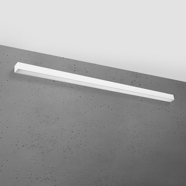 Applique barre moderne LED blanche 150 cm installée sur un mur de béton