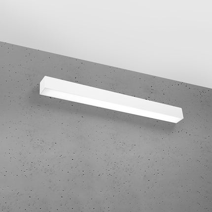 Applique barre moderne LED blanche installée sur un mur de béton