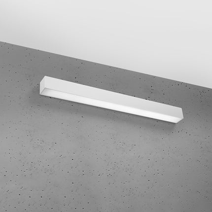 Applique barre moderne LED grise installée sur un mur de béton