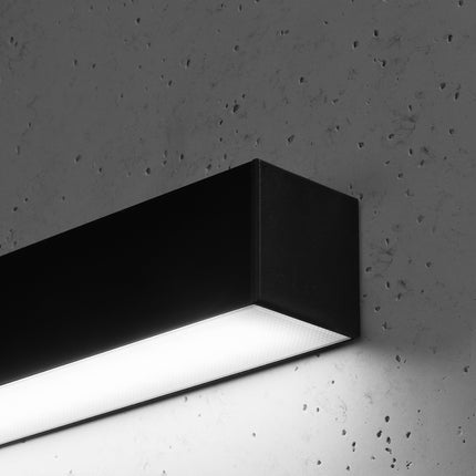 Détail du diffuseur opale de l'applique barre moderne LED noire sur mur béton