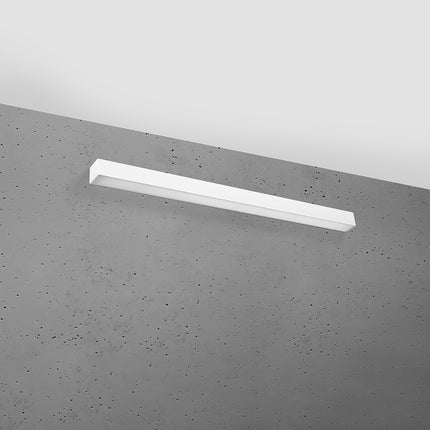 Applique barre moderne LED blanche 90 cm installée sur un mur de béton