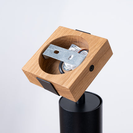 Détail du socle en bois naturel et de la fixation en acier noir