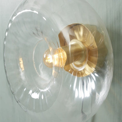 Détail de la fixation dorée et de l'ampoule de l'applique Brussels transparente