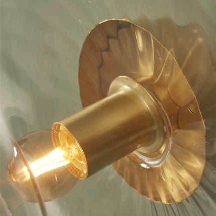 Vue intérieure du verre transparent de l'applique Brussels et de son ampoule allumée