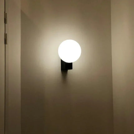 Applique murale bulle en métal au-dessus d'une tête de lit