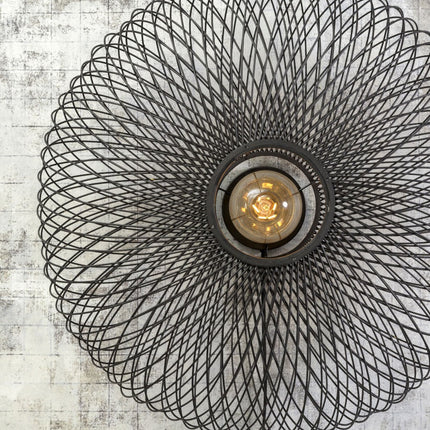 Gros plan sur le centre de l'applique Cango, ampoule à filament visible à travers la structure en fer noir ajouré.