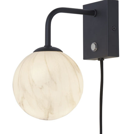Applique murale Carrara globe marbre et noir allumée en soirée, halo lumineux doux