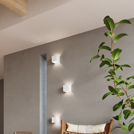 Trois appliques carrées blanches LED IP54 allumées dans un couloir loft
