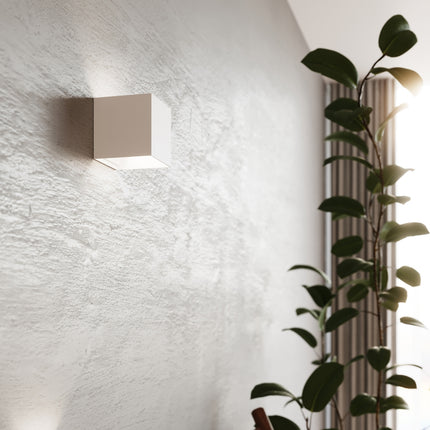 Détail rapproché d'une applique carrée blanche LED IP54 allumée au mur