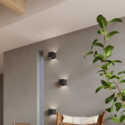 Trois appliques carrées noires LED IP54 allumées dans un couloir loft