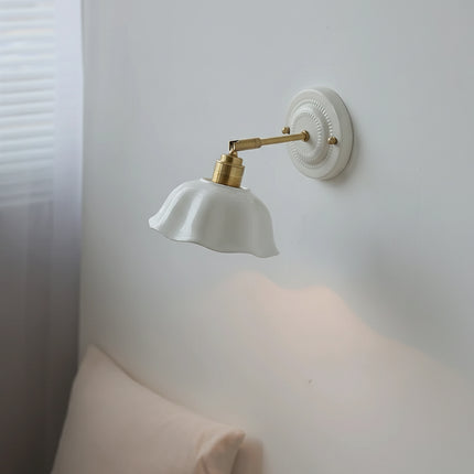 Applique murale en céramique blanche vue de profil, bras orientable en laiton doré