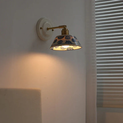 Applique murale en céramique florale bleue allumée diffusant une lumière chaude dans une ambiance de chambre