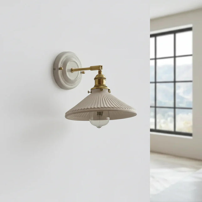 Applique vintage en céramique blanc crème et bras en laiton orientable dans une pièce lumineuse