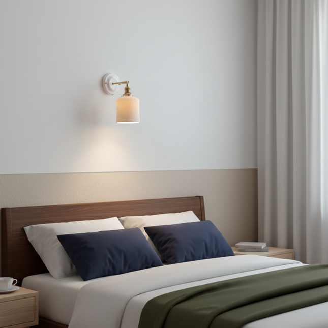 Applique en céramique et laiton allumée au-dessus d'une tête de lit dans une chambre