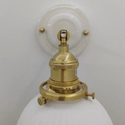 Détail de la douille et du bras orientable en laiton doré sur la platine en céramique