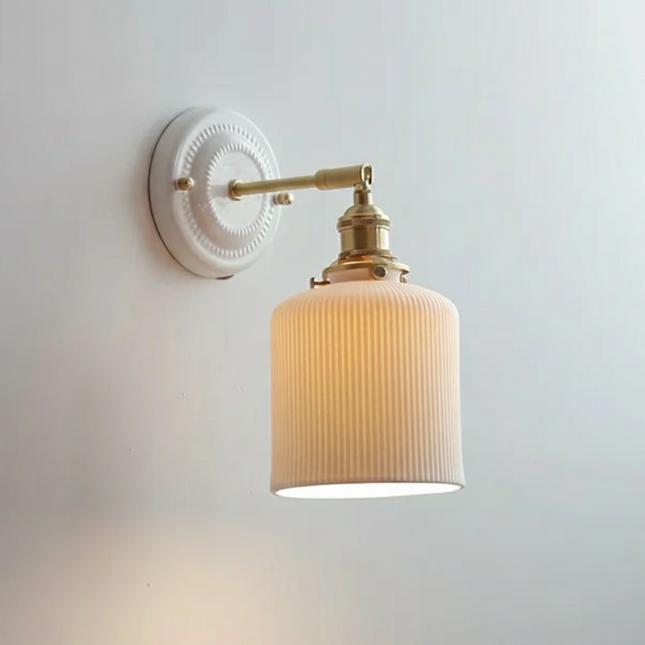 Applique murale en céramique rainurée avec bras orientable en laiton doré sur mur clair