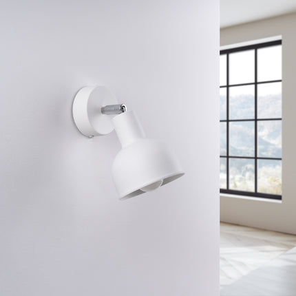 Applique Elba blanche installée au-dessus d'une tête de lit dans une chambre