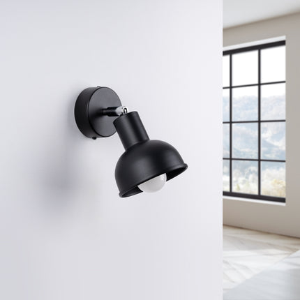 Applique Elba noire installée au-dessus d'une tête de lit dans une chambre