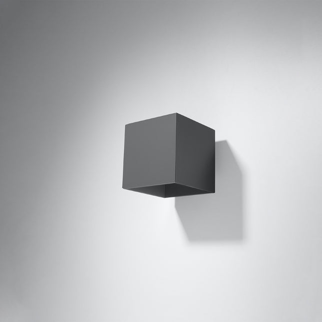 Applique cube anthracite fixée sur un mur gris, silhouette compacte