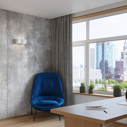 Applique Cube LED 2 feux blanche installée sur un mur en béton dans un salon contemporain