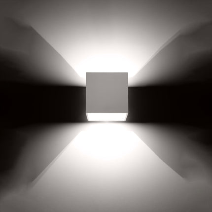 Applique cube blanche projetant un faisceau de lumière net