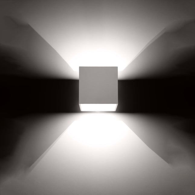 Applique cube blanche projetant un faisceau de lumière net
