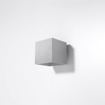 Applique murale cube LED grise allumée dans un salon contemporain
