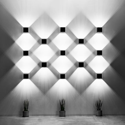 Applique murale cube noire près d'une tête de lit