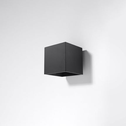 Applique murale cube LED noire allumée dans un salon contemporain