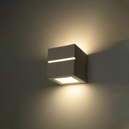 Applique Cube Ligne en céramique blanche posée dans une chambre moderne