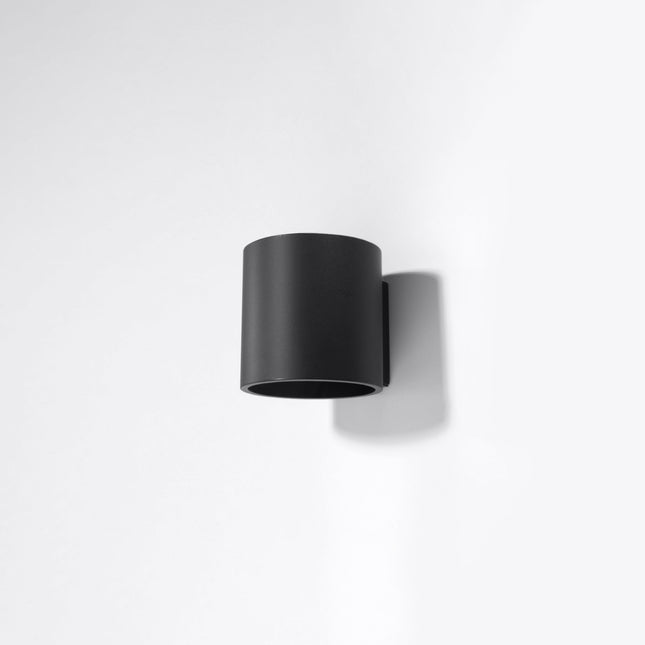 Suspensions et appliques cylindriques noires assorties dans un salon contemporain