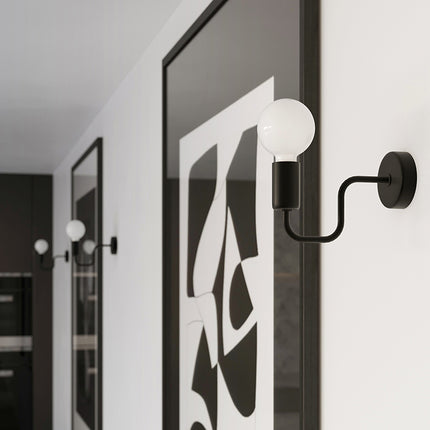 Applique murale Design Flex noire allumée près d'un cadre graphique dans un couloir