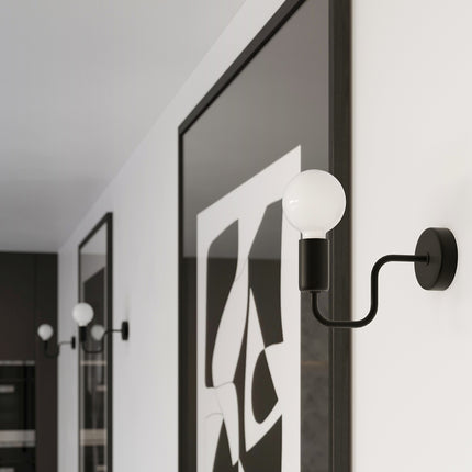 Gros plan sur l'applique murale Design Flex noire près d'un cadre graphique