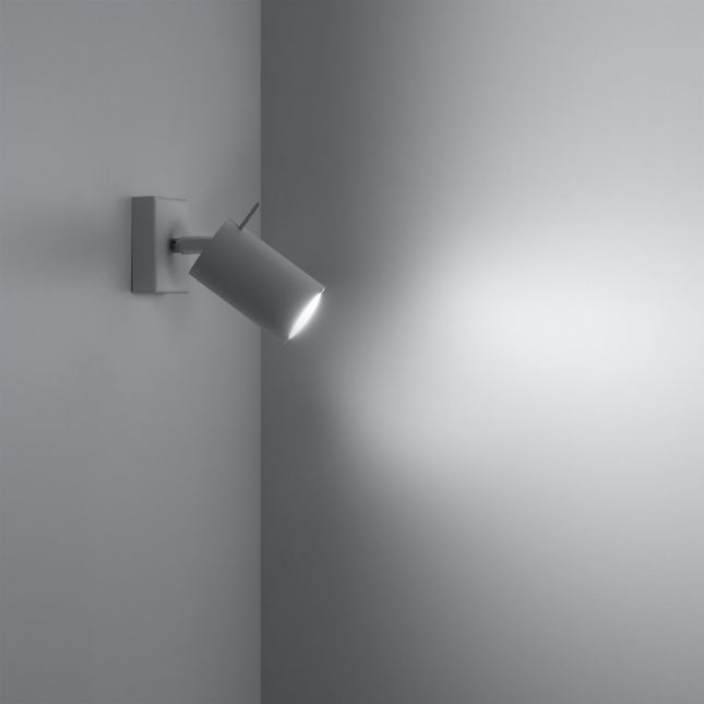 Applique blanche allumée dans un angle de mur, faisceau lumineux dirigé sur la paroi