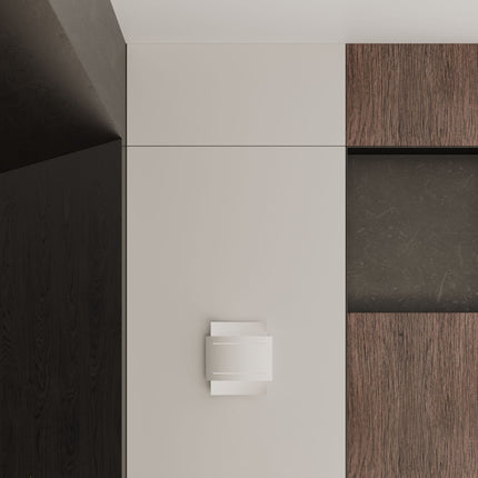 Gros plan sur l'applique Double Rampe blanche fixée au mur, entre une paroi claire et un habillage bois.