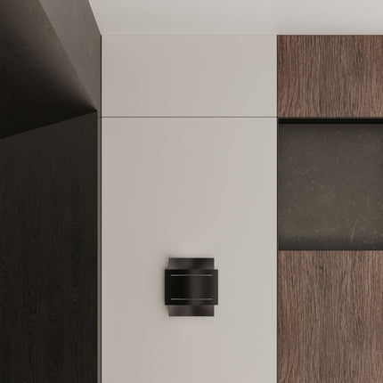 Gros plan sur l'applique Double Rampe noire fixée au mur, entre une paroi claire et un habillage bois.