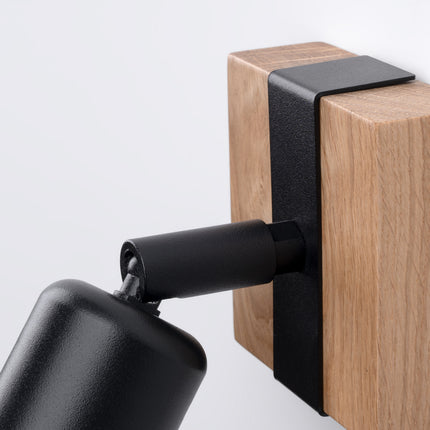 Détail du mécanisme orientable de l'applique Élégance Bois Noir, articulation en métal noir sur bloc de bois