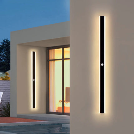 Applique extérieure LED linéaire noire installée près d'une entrée et d'une piscine