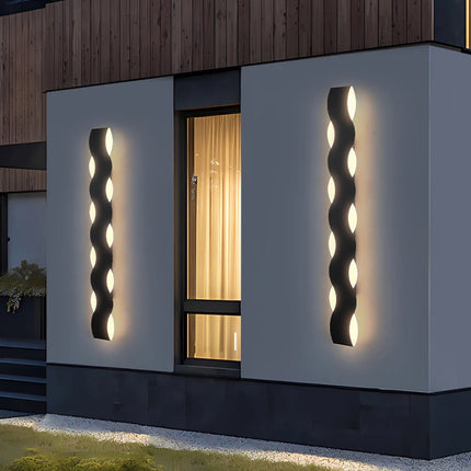 Deux appliques murales extérieures noires en forme de vague sur un mur de maison contemporaine